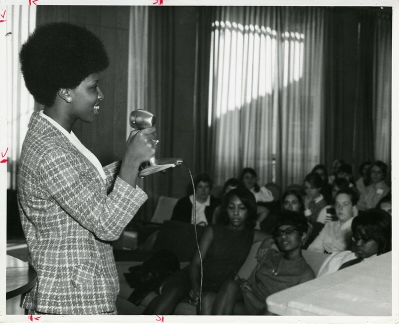 Student stands and speaks in front of a group of students (1968).