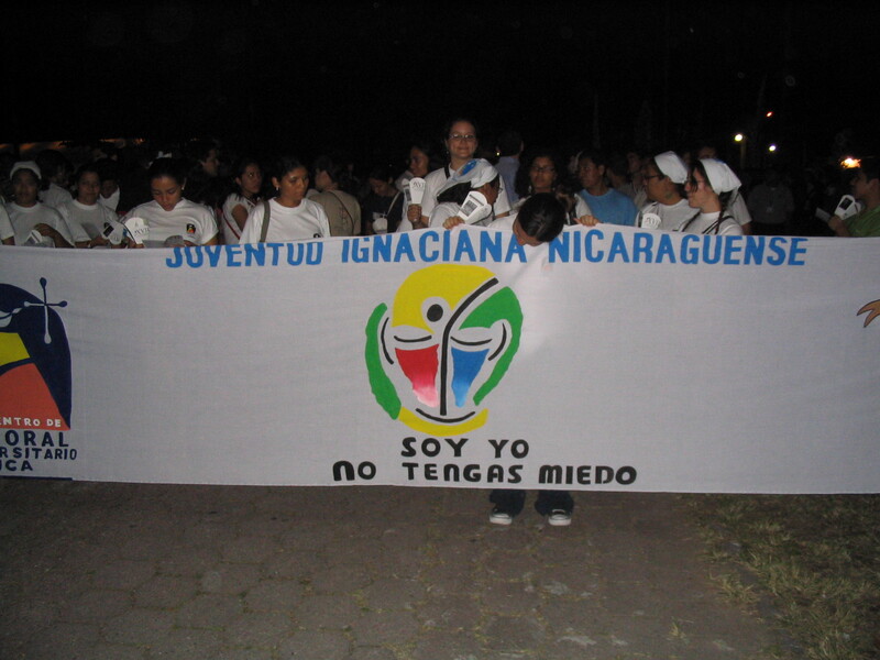 A group of people holding a banner and marching to commemorate the Salvadoran martyrs.
